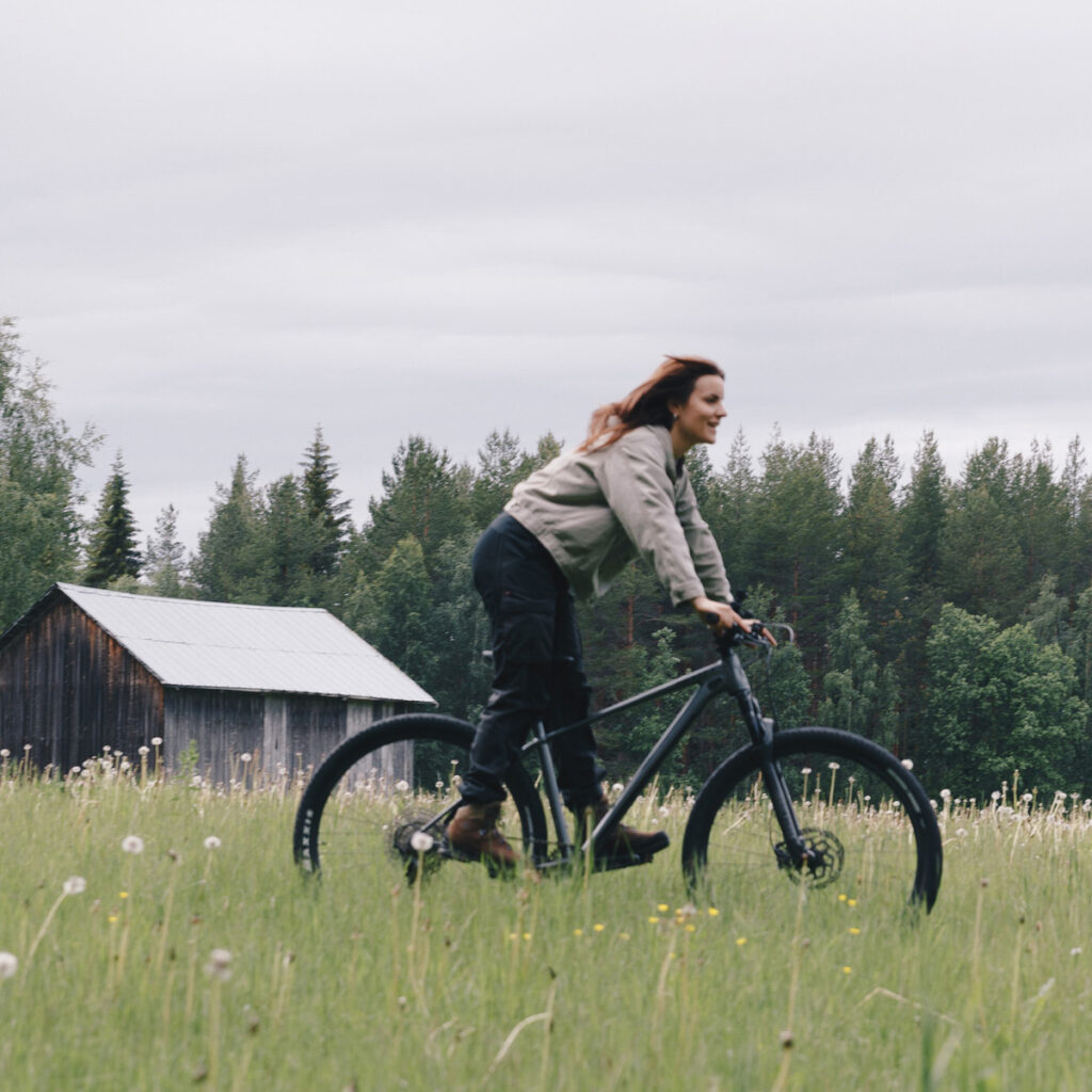 Kvinna cyklar över en åker