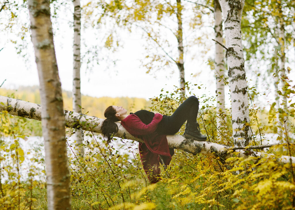 Yoga - kvinna ligger och vilar på en björk