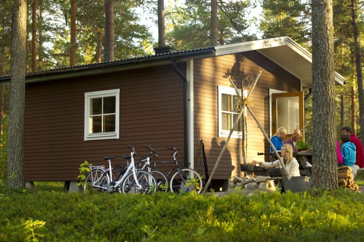 stuga med männsikor som äter mat utanför på sommaren